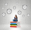 © ImageFlow - young woman sitting on pile of books with hanging clocks around