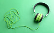 A pair of modern headphones, on green background