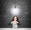 © ImageFlow - woman with hands and head on pile of books thinking