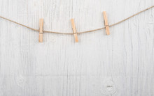 Clothespins On Rope Three Clothespins On Rope On White Wooden Background