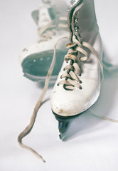 Vintage womens white shabby figure skates on white background.