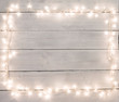 Christmas lights on white painted wooden background with copy sp