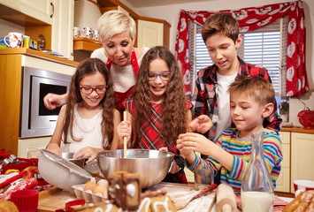 Happy family preparing christmas pastries and cake together