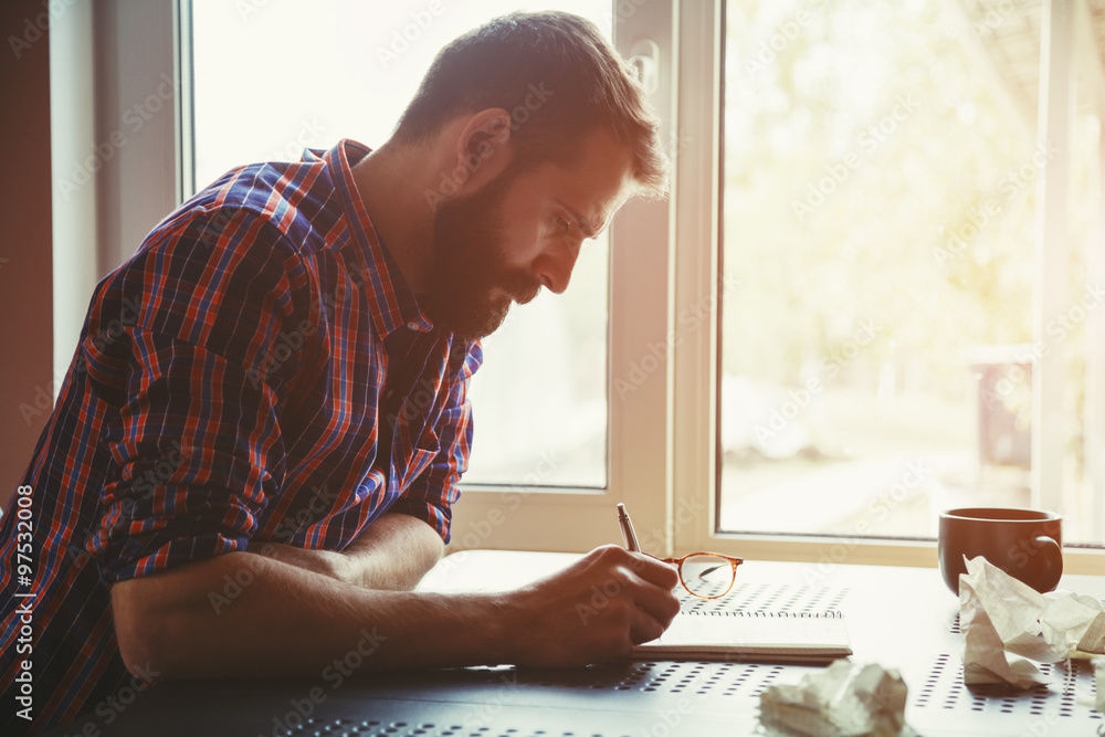 bearded man writing in notebook with pen and paper balls Stock Photo ...