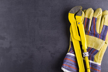 Poster - Wrench, working gloves and brass fittings on crude floor background. 