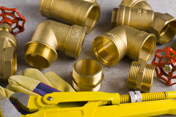 Poster - Wrench, working gloves and brass fittings on crude floor background. 