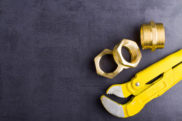 Poster - Wrench, working gloves and brass fittings on crude floor background. 