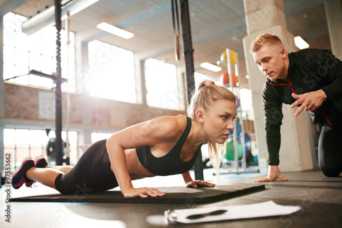 Cuadros en Lienzo Female exercising with personal trainer at gym