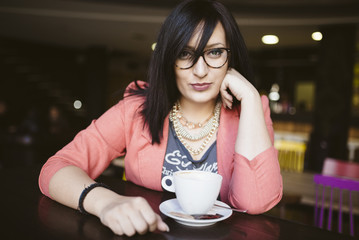 pierced girl drinking coffee in coffee shop