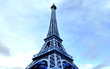 3D Eiffel Tower in Paris on blue sky background.