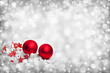 Weihnachtshintergrund mit zwei roten Kugeln,Sternen auf grauem Hintergrund mit Lichtpunkten