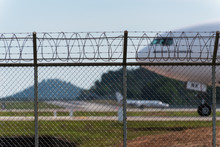 Airport Fence And Air Plane Behind