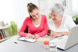 cheerful young woman helping an elderly woman with pills medical prescription
