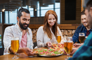 Canvas Print - friends eating pizza with beer at restaurant