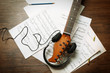 Electric guitar and headphones with music notes on wooden background