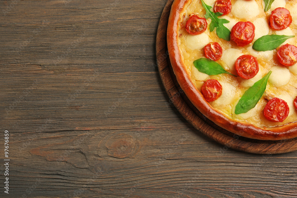 Pizza Margherita with arugula on wooden background