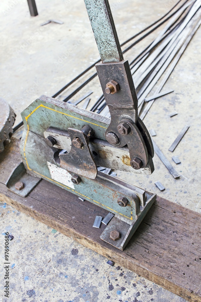An old, rusty and aged pedestal of bolt cutters with wire, iron, steel ...