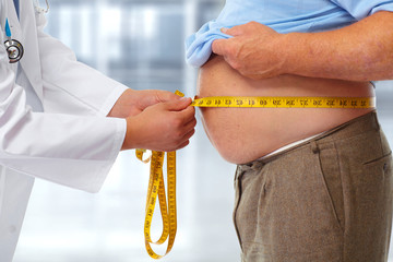 Doctor measuring obese man stomach.