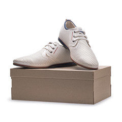 Wall Mural - Men's summer elegant white leather shoes with laces on a cardboard box