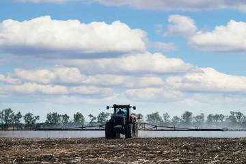 Poster - The tractor works in a field