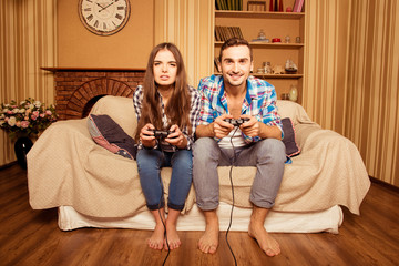 Wall Mural - Young couple in love playing video games