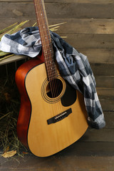 Sticker - Acoustic guitar and blue checkered shirt against box with hay on wooden background