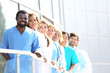 © Africa Studio - Smiling medics team standing in a row near the clinic