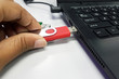 © zasazana - Close up of a woman hand plugging a pendrive on a laptop in soft focus