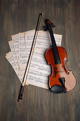 Sticker - Violin and music papers on wooden background