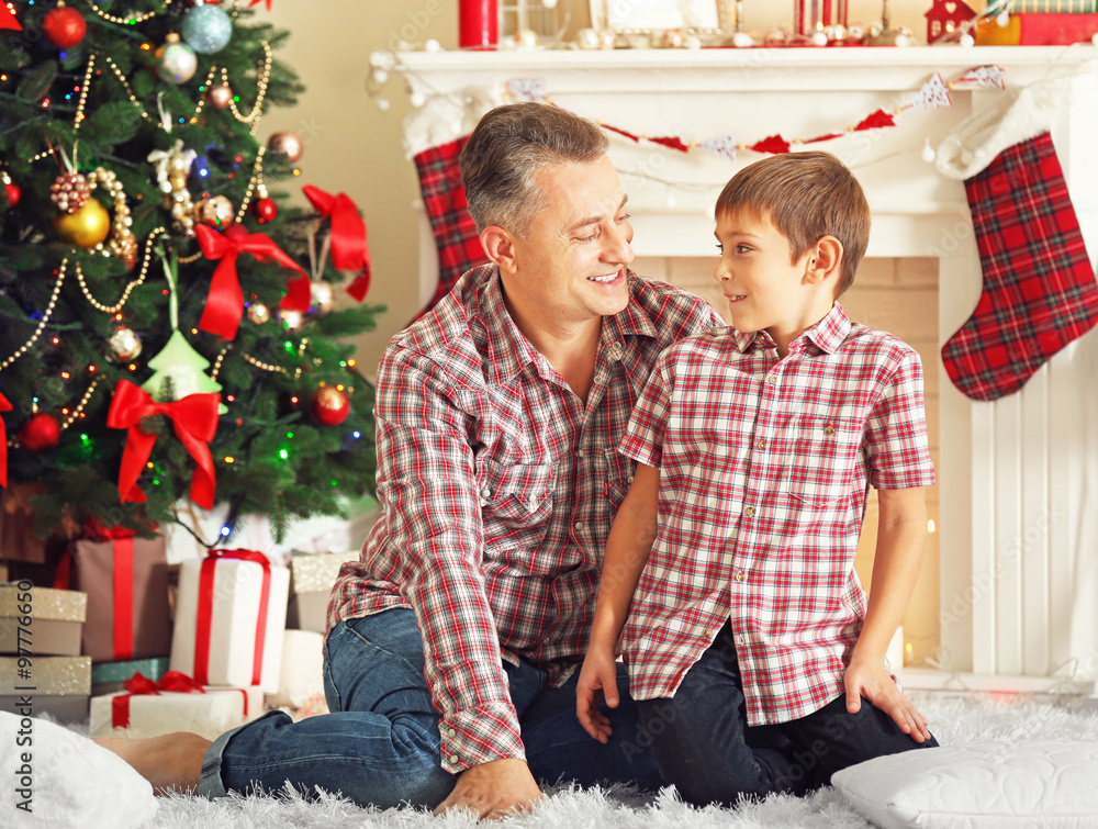Father and son on Christmas interior background