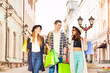 © Sergey Novikov - Three smiling friends walking with shopping bags