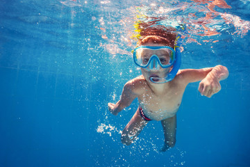 Underwater kid in swimming pool with mask.