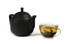 Black Ceramic Teapot And A Cup Of Green Tea Isolated
