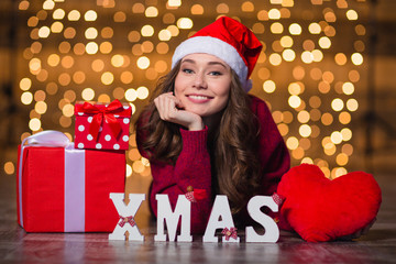 Canvas Print - Cheerful beautiful girl lying near letters spelling word Xmas