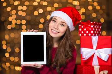 Sticker - Smiling woman in santa claus hat holding tablet blank screen