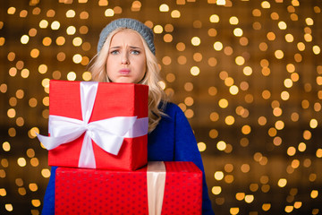 Poster - Woman holding gift boxes over holidays lights background