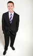 © desertsolitaire - A young business man stands relaxed and smiling.
