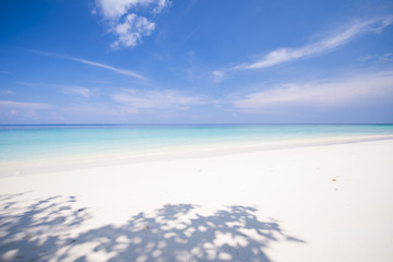 tropical beach with blue sky and calm blue sea surf