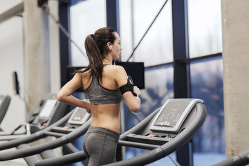 woman with earphones exercising on treadmill