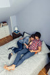 © David Pereiras - Couple in love looking electronic tablet on bed