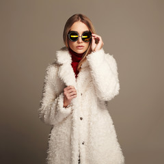 Wall Mural - beautiful winter girl in white fur and sunglasses. winter fashion