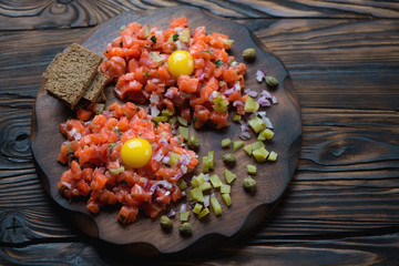 Wall Mural - Salmon tartar on a rustic wooden background, studio shot