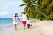 Young family with two kids walking at tropical beach