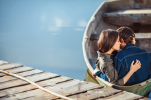 Happy Romantic Couple Rowing A Small Boat On Lake