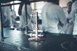 Bunsen burner used for endothermic reactions.Laboratory bunsen burner,single gas flame used for sterilization,combustion and heating.Gas flame in laboratory.Students in class blurred in background