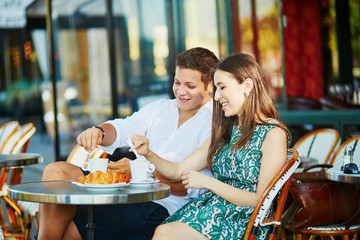 Wall Mural - Young romantic couple in a cozy outdoor cafe in Paris, France