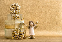 Gift Boxes And Little Angel On Bright Golden Background