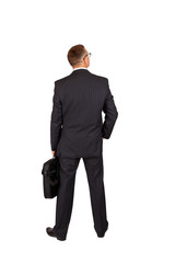 back view of a walking business man with a notebook case and looking to a side, full length portrait