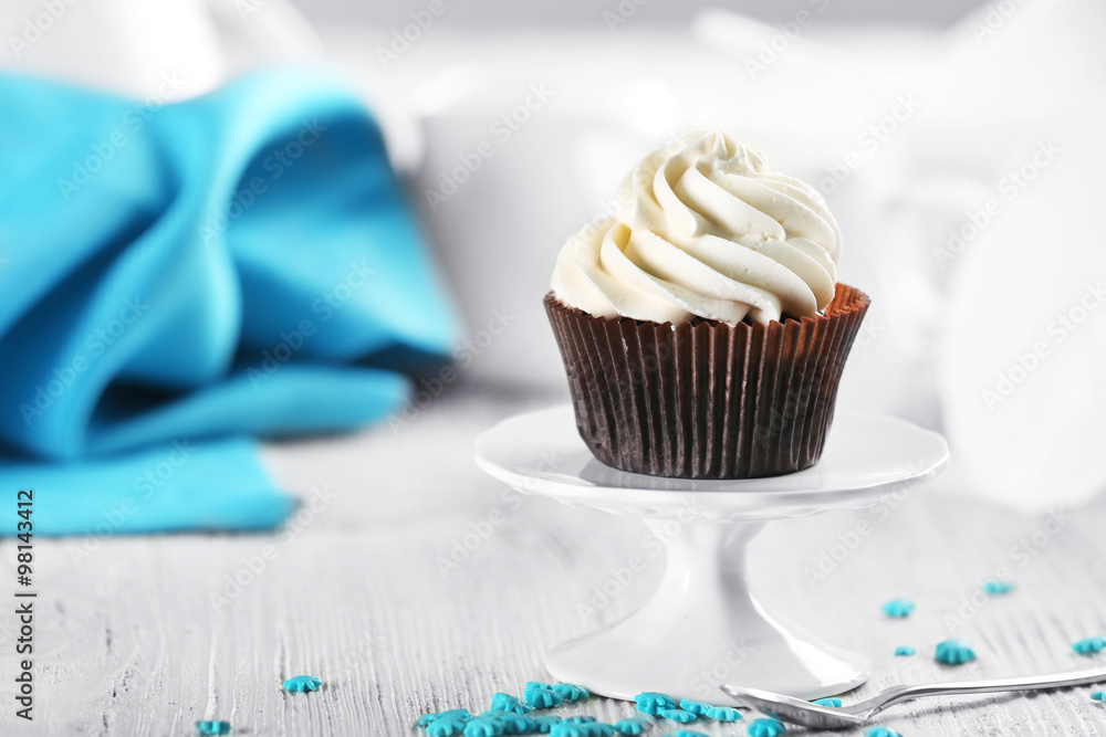 Delicious chocolate cupcake with cream on decorated wooden  table, close up