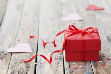 Wall Mural - Gift box with red bow ribbon and paper heart on wooden table for Valentines day